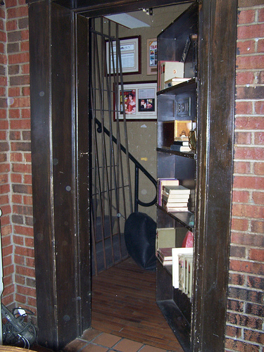 Hidden swing-in bookcase door reveals hidden stairs