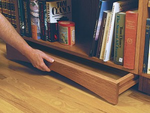 Hidden compartment drawer concealed under bookshelf